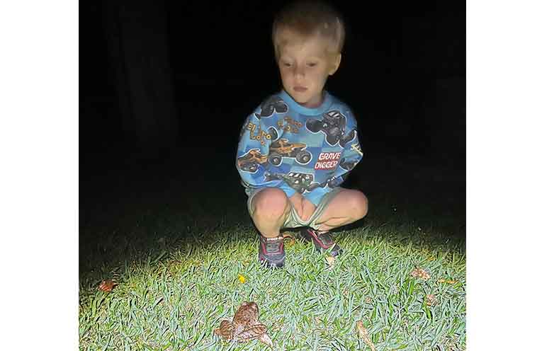 Xavier Gentle with the endangered Giant Barred Frog on the Karangi property. Photo: supplied.