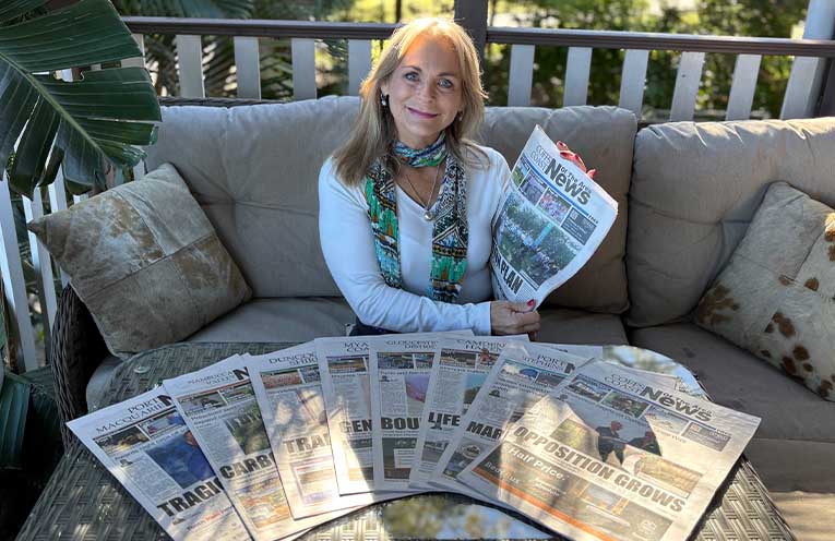 Eve with a few of her favourite things - eight different mastheads of News Of The Area. Photo: Angus Cheetham.
